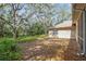Backyard featuring mature trees, lush vegetation, and the home's exterior at 6237 Greenwich Dr, Tampa, FL 33647