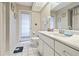 Bright bathroom featuring a white vanity, tiled floors, and a door to the exterior at 6237 Greenwich Dr, Tampa, FL 33647