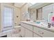 Bright bathroom with white vanity, tile flooring, and an exterior door at 6237 Greenwich Dr, Tampa, FL 33647