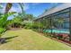 Backyard featuring an in-ground swimming pool with lush landscaping and a screened enclosure at 625 Fayette S Dr, Safety Harbor, FL 34695