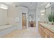 Luxurious bathroom with a soaking tub, glass-enclosed shower, and dual vanities at 6310 W Maclaurin Dr, Tampa, FL 33647