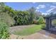 Beautiful backyard with lush foliage, green lawn and a view of the screened-in porch at 7107 Colonial Lake Dr, Riverview, FL 33578