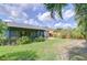 Backyard with a grassy lawn, tropical foliage and a screened patio at 7107 Colonial Lake Dr, Riverview, FL 33578