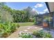 Backyard featuring a patio, grill, lush green grass, tropical foliage, and a stone walkway at 7107 Colonial Lake Dr, Riverview, FL 33578