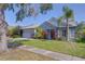 Charming one-story home with a blue exterior, well-maintained lawn and mature landscaping at 7107 Colonial Lake Dr, Riverview, FL 33578