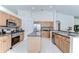 Bright kitchen featuring wood cabinets, stainless steel appliances, island, and white tile flooring at 7107 Colonial Lake Dr, Riverview, FL 33578
