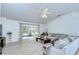Bright living room with a ceiling fan, neutral decor, and sliding glass doors to a screened patio at 7107 Colonial Lake Dr, Riverview, FL 33578