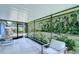 Enclosed patio featuring a concrete floor, comfortable seating, and views of the tropical backyard at 7107 Colonial Lake Dr, Riverview, FL 33578
