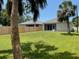 Large, well-maintained backyard with a wooden fence and mature palm trees at 7635 N 55Th N St, Pinellas Park, FL 33781