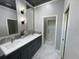 Bathroom featuring double sinks, decorative mirrors, marble countertop, and gray cabinetry at 7635 N 55Th N St, Pinellas Park, FL 33781