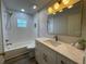 Well-lit bathroom featuring a tub, shower, marble countertop, and modern fixtures at 7635 N 55Th N St, Pinellas Park, FL 33781