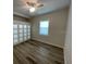 Bright bedroom with wood floors, ceiling fan, and natural light from the window at 7635 N 55Th N St, Pinellas Park, FL 33781