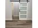 Modern barn door with glass panels and black hardware provides a stylish transition at 7635 N 55Th N St, Pinellas Park, FL 33781