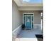 Elegant teal front door framed by sidelights and a transom window, set within a decorative stone facade at 7635 N 55Th N St, Pinellas Park, FL 33781