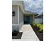 View of the home's entrance, complemented by manicured landscaping and a walkway leading to the inviting teal front door at 7635 N 55Th N St, Pinellas Park, FL 33781