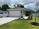 Inviting single-story home showcasing an attached two-car garage, teal front door, and a beautifully landscaped front yard at 7635 N 55Th N St, Pinellas Park, FL 33781