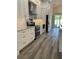 Modern kitchen with stainless steel appliances, white cabinetry and sleek gray floors at 7635 N 55Th N St, Pinellas Park, FL 33781
