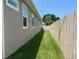 View of the house's side yard, highlighting the lush green grass and the boundary defined by a wooden fence at 7635 N 55Th N St, Pinellas Park, FL 33781