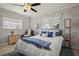 Bright bedroom with palm wallpaper, a ceiling fan, and a comfortable bed with blue accents at 811 Woodley Rd, Clearwater, FL 33764