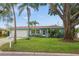 Charming single-story home with lush landscaping, mature trees, and a well-manicured lawn at 811 Woodley Rd, Clearwater, FL 33764