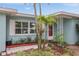 Inviting front entrance features tropical landscaping and a bright red front door at 811 Woodley Rd, Clearwater, FL 33764