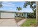 Charming single-story home featuring a well-maintained lawn, lush landscaping, and a two car garage at 811 Woodley Rd, Clearwater, FL 33764