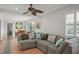 Open living room with a ceiling fan, comfortable sectional sofa, and view of dining room at 811 Woodley Rd, Clearwater, FL 33764