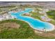 Stunning aerial view of a vibrant community featuring a large, resort-style lagoon and modern amenities at 8891 Bower Bass Cir, Wesley Chapel, FL 33545