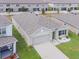 Aerial view of a well-kept house featuring a two-car garage and landscaped front yard, surrounded by neighboring homes at 8891 Bower Bass Cir, Wesley Chapel, FL 33545