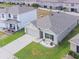 Bird's eye view of a cozy home with a well-maintained lawn and a concrete driveway, nestled in a residential area at 8891 Bower Bass Cir, Wesley Chapel, FL 33545