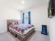 Bedroom featuring a wooden bed frame with a colorful comforter and a window with curtains at 8891 Bower Bass Cir, Wesley Chapel, FL 33545