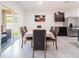 Bright dining room with a large table, stainless steel appliances, and sliding glass doors leading to the backyard at 8891 Bower Bass Cir, Wesley Chapel, FL 33545