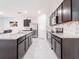 Well-equipped kitchen with granite countertops, stainless steel appliances, dark wood cabinets and an island with sink at 8891 Bower Bass Cir, Wesley Chapel, FL 33545