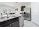 Well-equipped kitchen with stainless steel appliances, double sink and granite countertops with a dining area in the background at 8891 Bower Bass Cir, Wesley Chapel, FL 33545