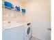 Laundry room with white washer and dryer, and shelving stocked with detergent and buckets at 8891 Bower Bass Cir, Wesley Chapel, FL 33545