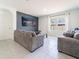 Comfortable living room featuring tile floors, neutral furniture, and large screen television for relaxation and entertainment at 8891 Bower Bass Cir, Wesley Chapel, FL 33545