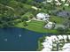 Aerial view showcases a luxurious community with golf course, pool, tennis courts, and stunning lake views at 9346 Southern Belle Dr, Weeki Wachee, FL 34613