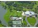 Aerial view highlighting a well-maintained golf course, community pool, and tennis courts near a tranquil lake at 9346 Southern Belle Dr, Weeki Wachee, FL 34613