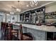 Elegant bar area with dark wood cabinets, granite countertop, pendant lighting, and stocked shelves at 9346 Southern Belle Dr, Weeki Wachee, FL 34613