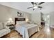 Bedroom with a queen bed, side tables with lamps, ceiling fan, wood-look floors, and seating at 9346 Southern Belle Dr, Weeki Wachee, FL 34613