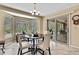 Dining area with a round table, four chairs, chandelier, and sliding glass doors leading to the outdoor area at 9346 Southern Belle Dr, Weeki Wachee, FL 34613