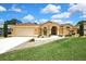 Inviting home exterior with a lush lawn, landscaped walkway and charming architectural details at 9346 Southern Belle Dr, Weeki Wachee, FL 34613