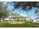 Exterior shot features a community clubhouse overlooking a green lawn with mature trees in the foreground at 9346 Southern Belle Dr, Weeki Wachee, FL 34613