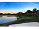 Scenic golf course view with lake and sand trap under a vibrant blue sky during sunset at 9346 Southern Belle Dr, Weeki Wachee, FL 34613