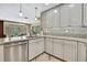 Modern kitchen featuring gray cabinets, stainless steel appliances, granite counters, and a view to the dining area at 9346 Southern Belle Dr, Weeki Wachee, FL 34613