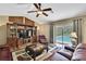 Cozy living room featuring a leather sofa, a wooden entertainment center, and sliding doors with a view of the pool at 9346 Southern Belle Dr, Weeki Wachee, FL 34613
