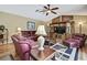 Living room with leather furniture, a wooden entertainment center, ceiling fan, and area rug at 9346 Southern Belle Dr, Weeki Wachee, FL 34613