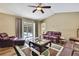 Bright living room with leather furniture, a patterned rug, ceiling fan, and sliding doors leading to the outdoor pool area at 9346 Southern Belle Dr, Weeki Wachee, FL 34613