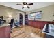 Office with wood-look floors, ceiling fan, desk, chairs, and built-in wood storage cabinets at 9346 Southern Belle Dr, Weeki Wachee, FL 34613