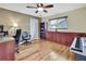 Office with wood-look floors, ceiling fan, desk, chairs, and built-in wood storage cabinets at 9346 Southern Belle Dr, Weeki Wachee, FL 34613